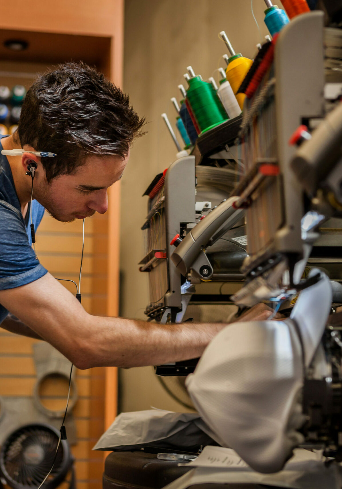 Worker preparing embroidery machine in t-shirt  printing workshop